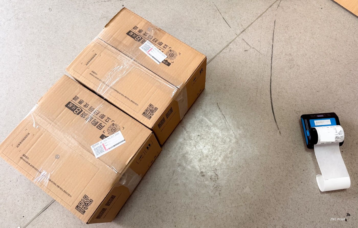 Thermal label printer next to shipping boxes