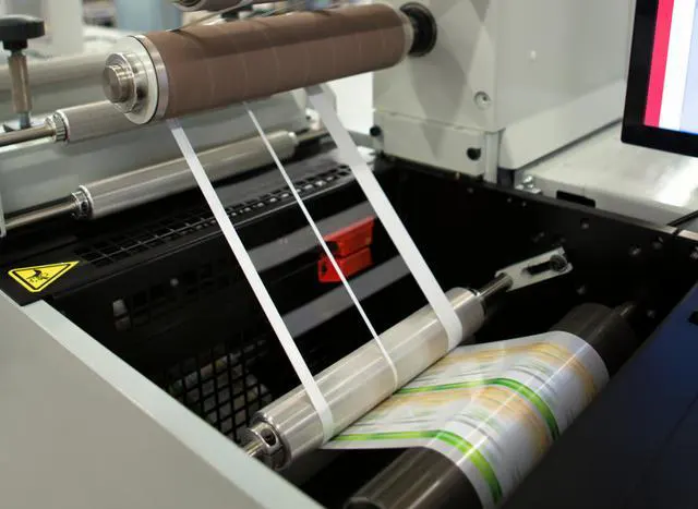 Film lamination roller pressing film onto a book cover